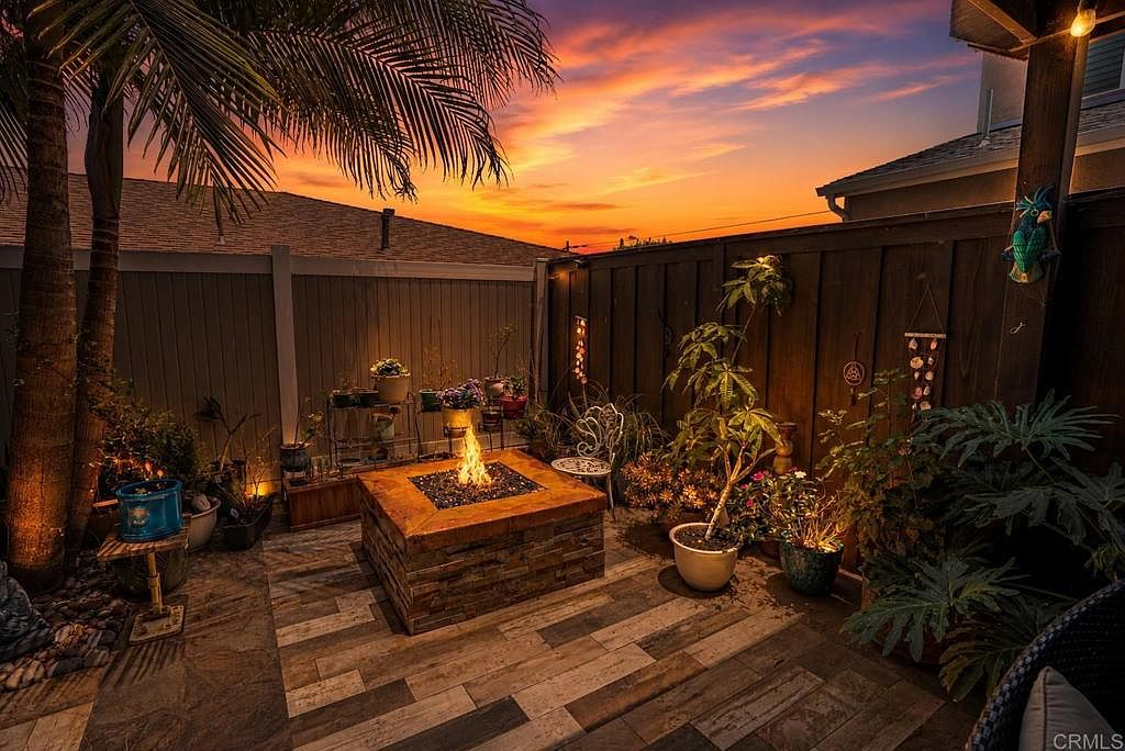 Backyard lounge with gas firepit and ambient string lights at golden hour