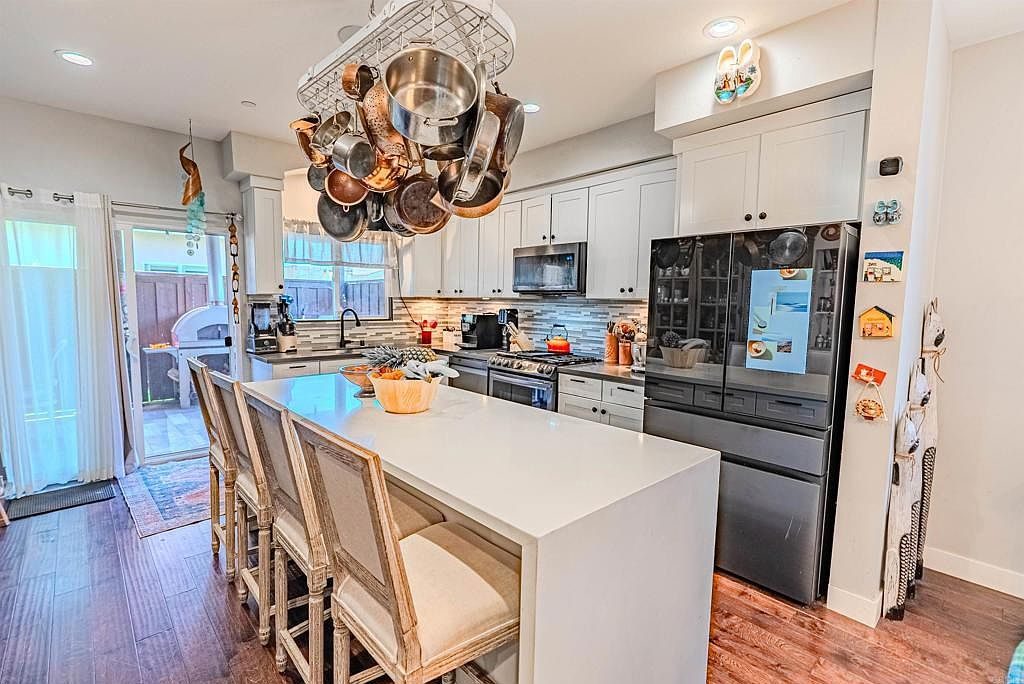 Modern kitchen with quartz waterfall island and walnut floors