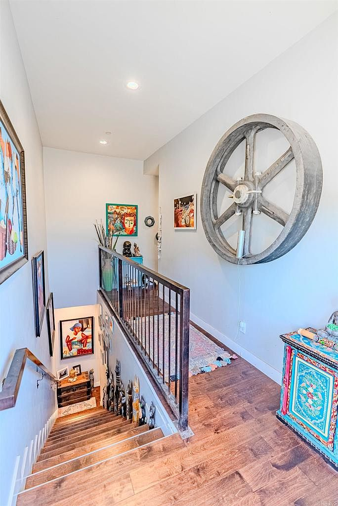 Stairway landing with hardwood floors and dark metal railings