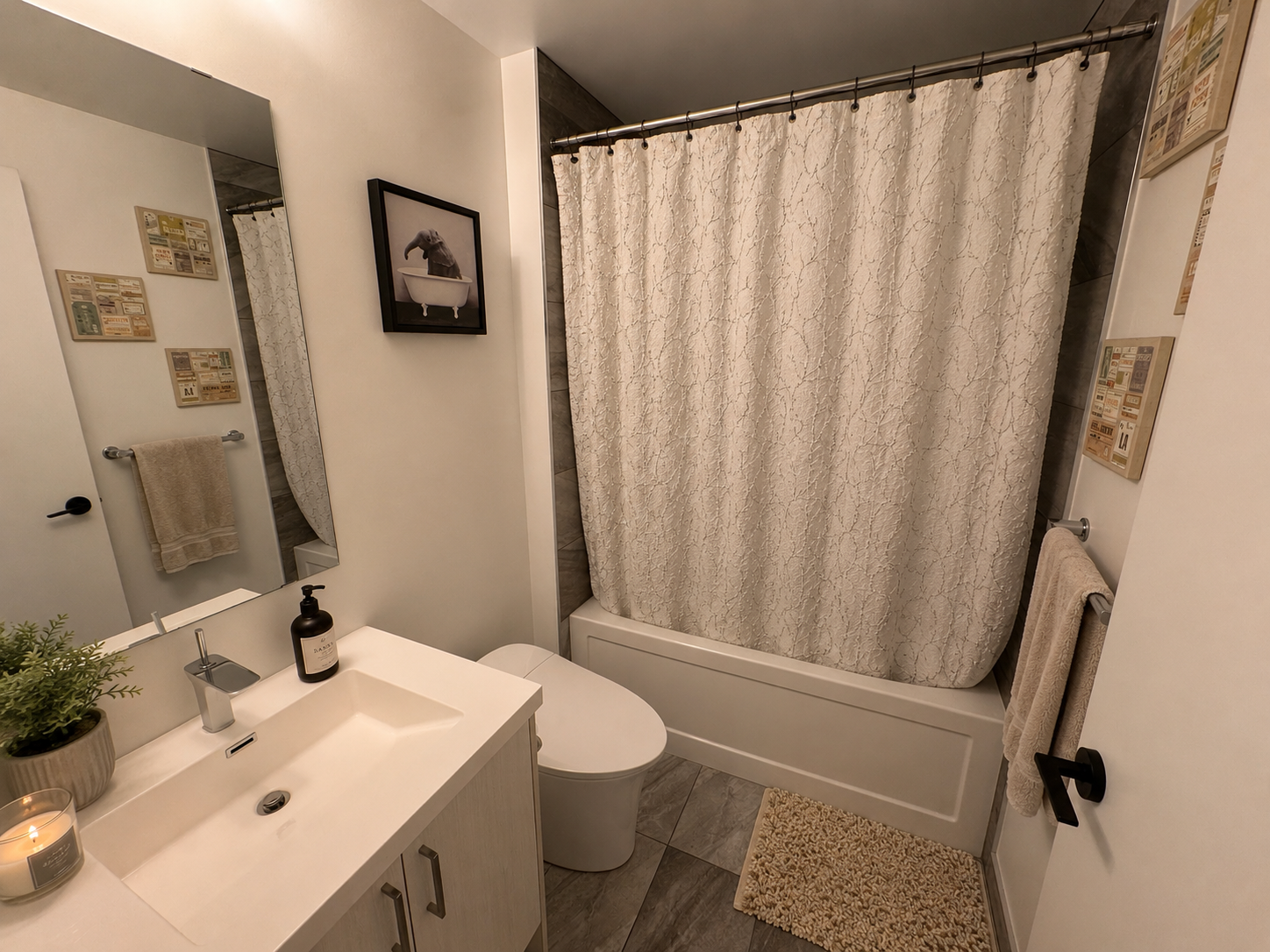 Main bathroom with vanity, tub, and elephant wall art