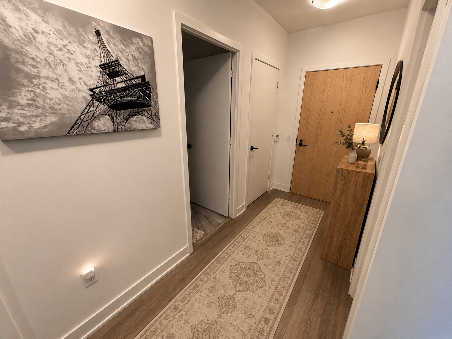 Entryway hallway with console cabinet, lamp, and Eiffel Tower wall art