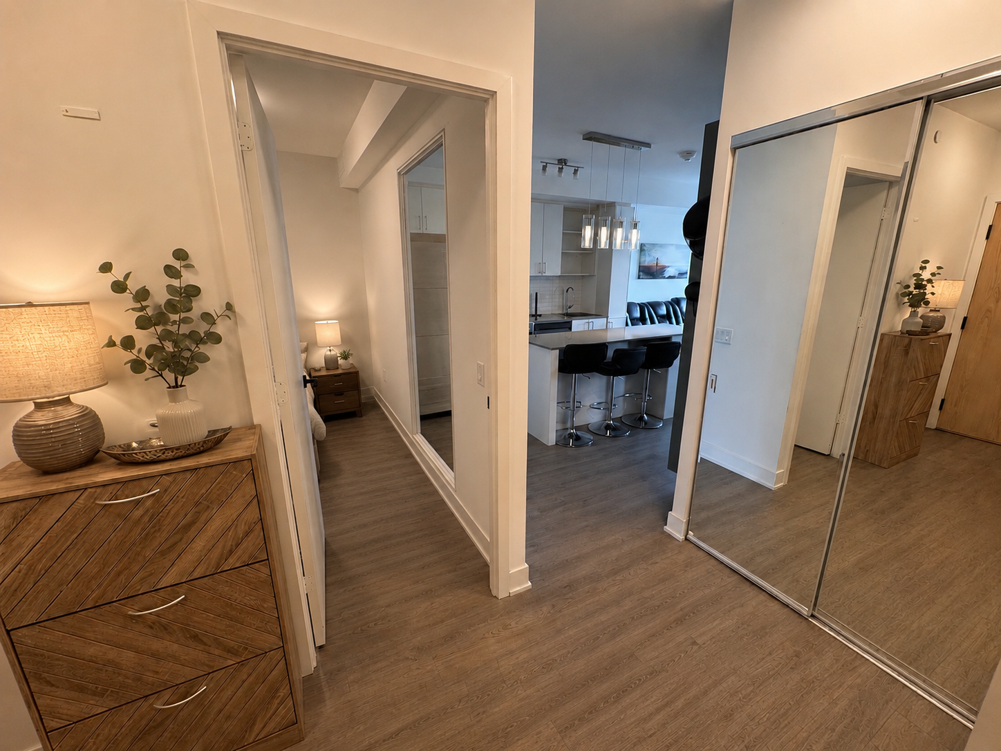 Interior entryway looking toward kitchen and bedroom with mirrored closet panels