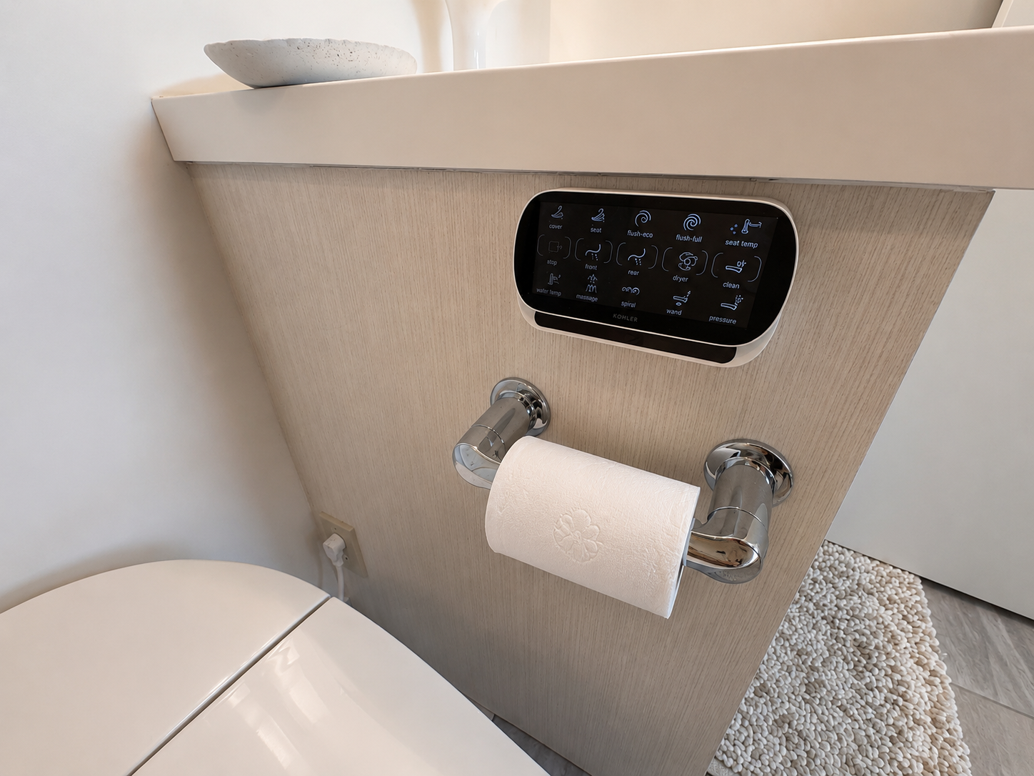 Ensuite bathroom with bedroom reflection visible in mirror and smart toilet controls