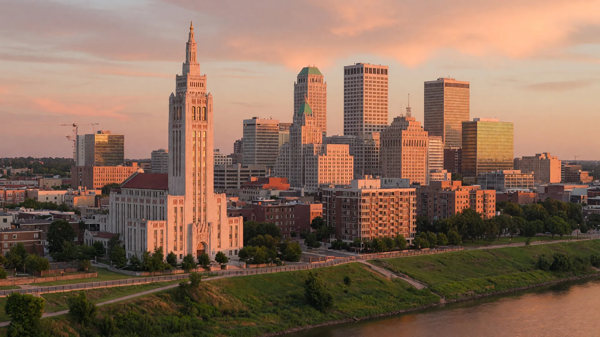 The Tulsa skyline at golden hour with historic Art Deco architecture visible above the Arkansas River