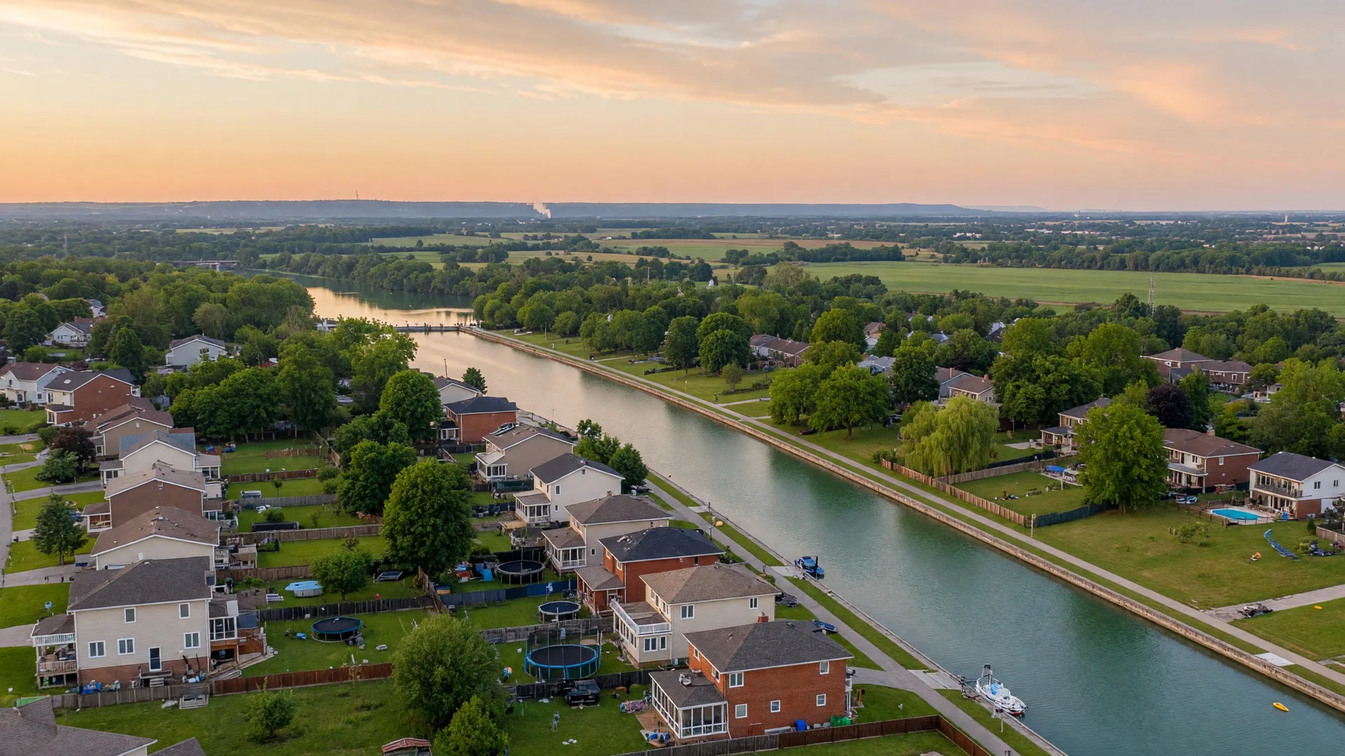 Wide view over the Niagara region with the Welland Canal winding through a peaceful residential neighbourhood at golden hour