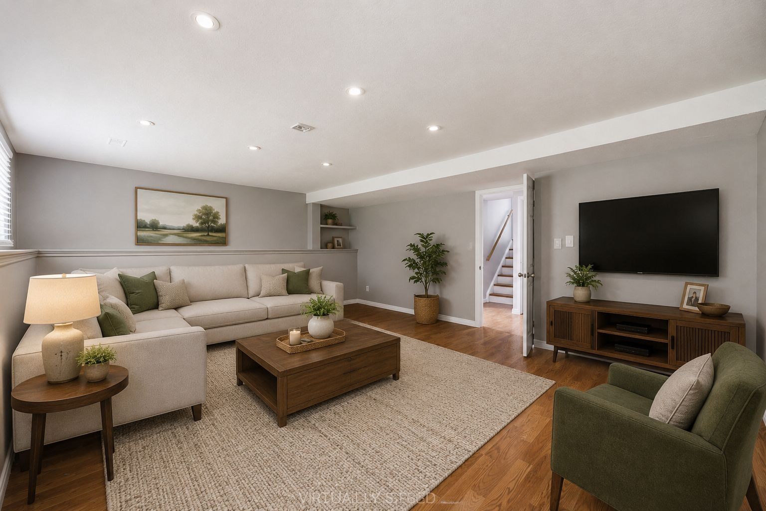 Virtually staged living room with sectional sofa, area rug, and media console