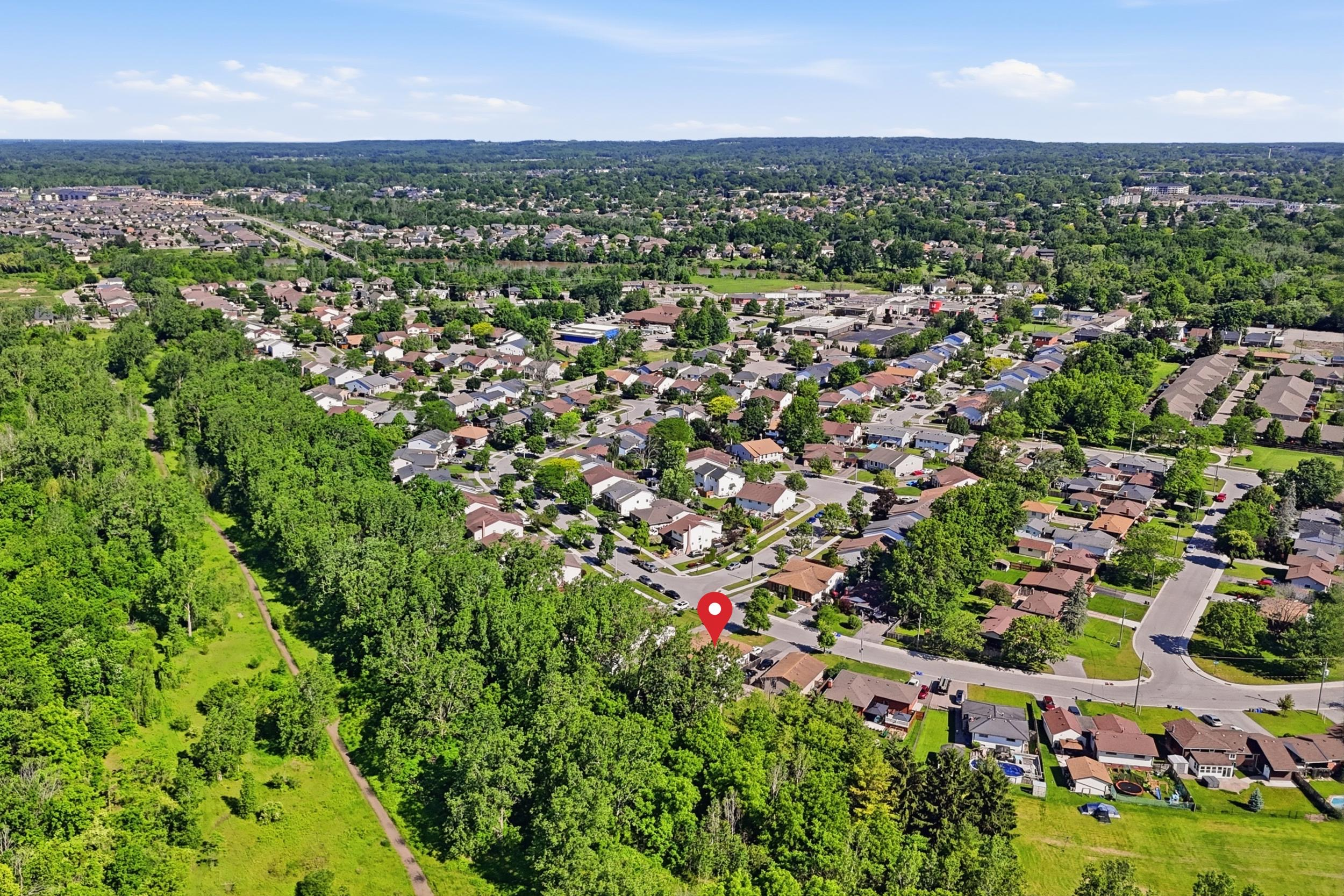 Aerial drone view of the Welland neighbourhood showing mature trees, park space, and proximity to the recreational waterway