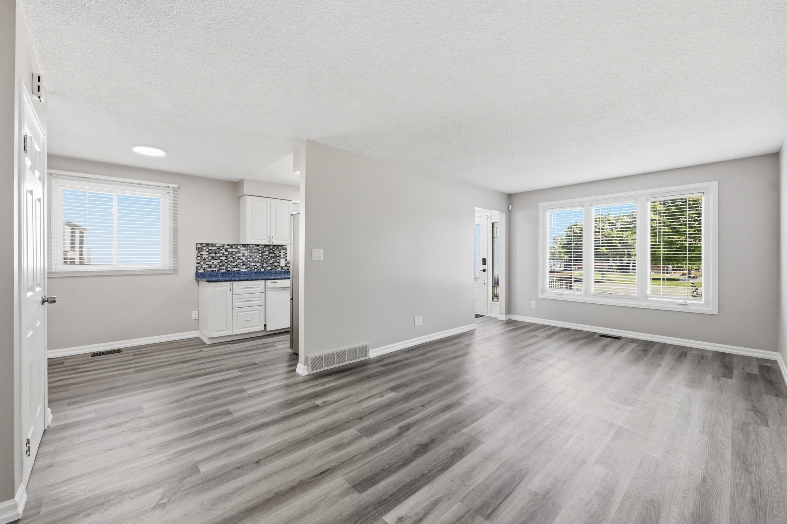 Open-concept living and dining with large picture windows