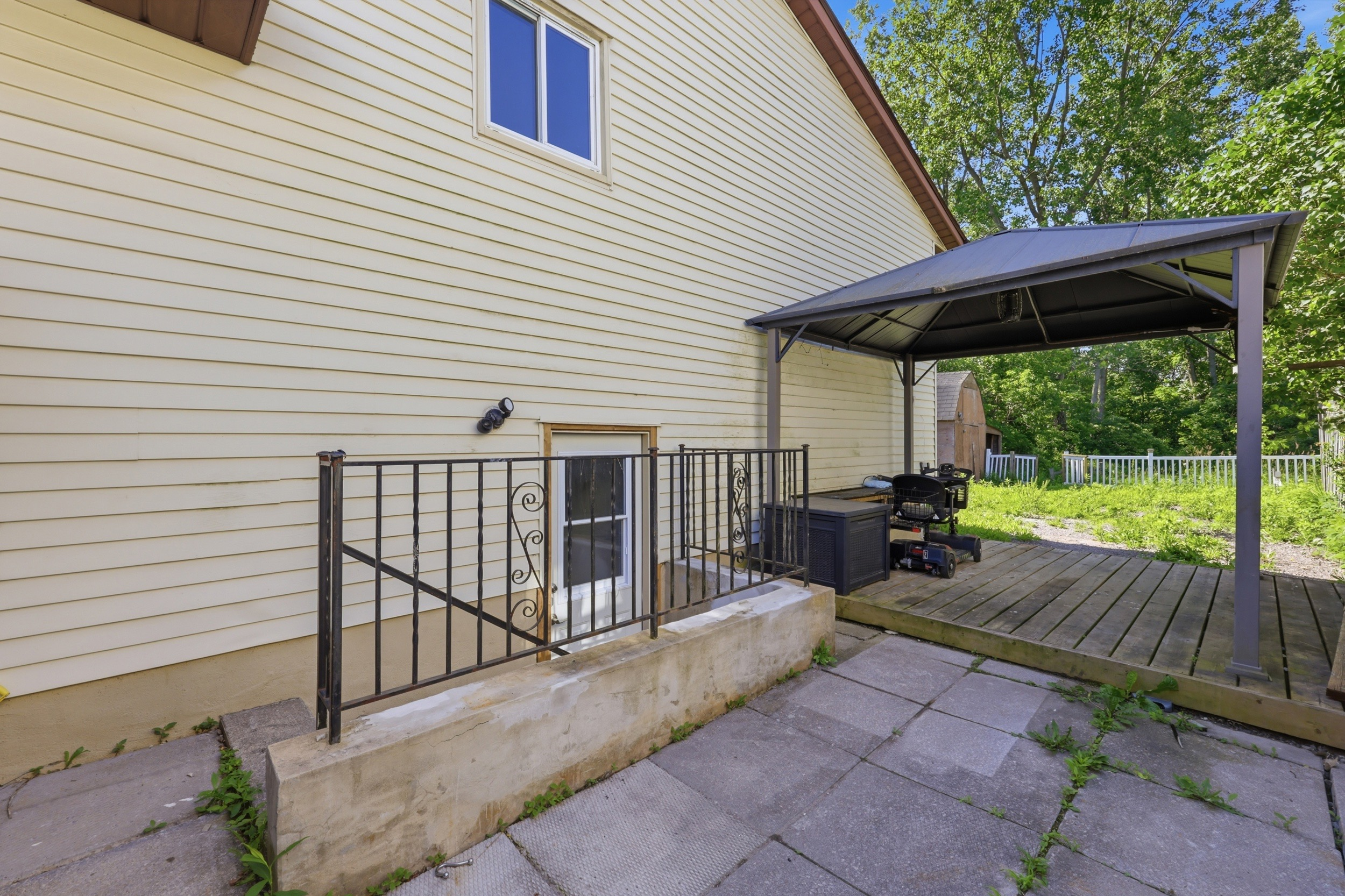 Backyard deck with gazebo frame and concrete patio