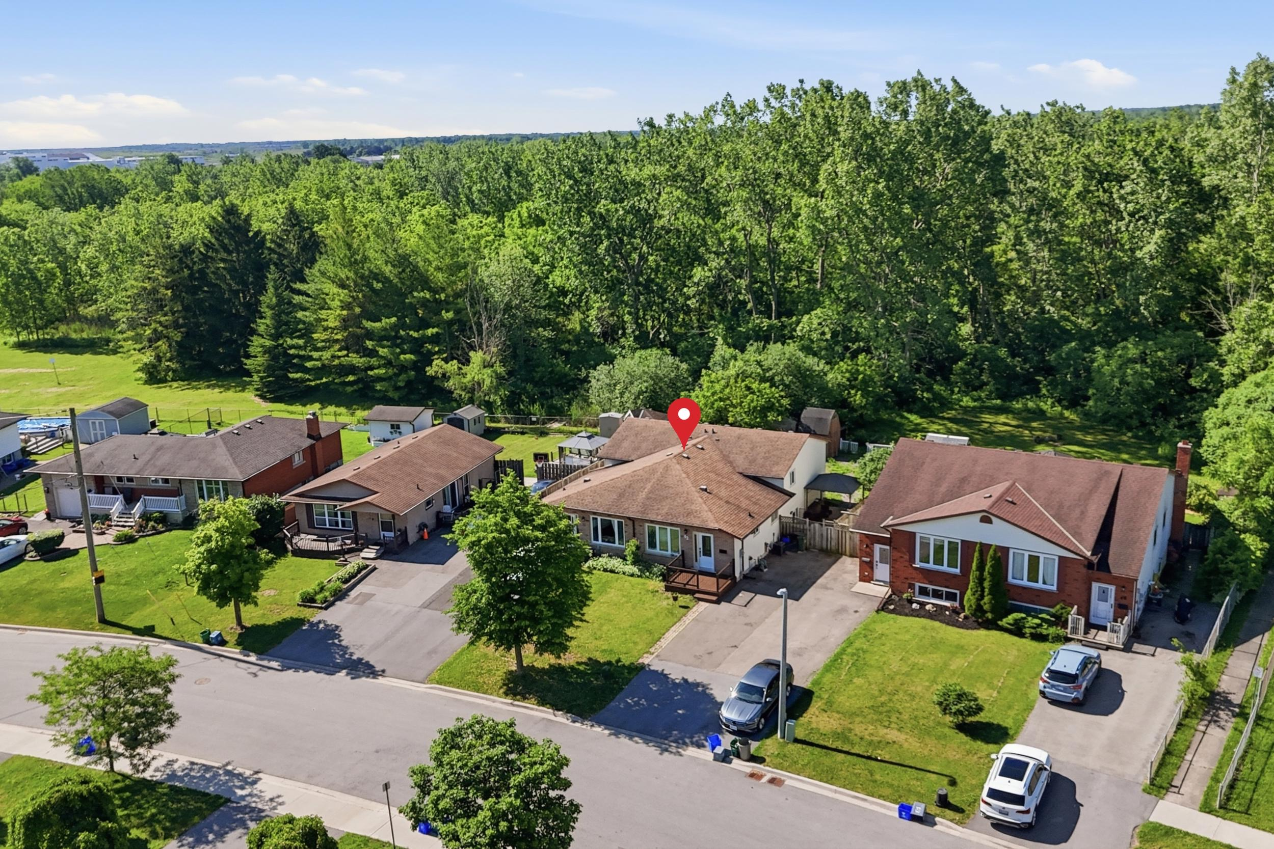 Aerial view of the property with mature trees and green space