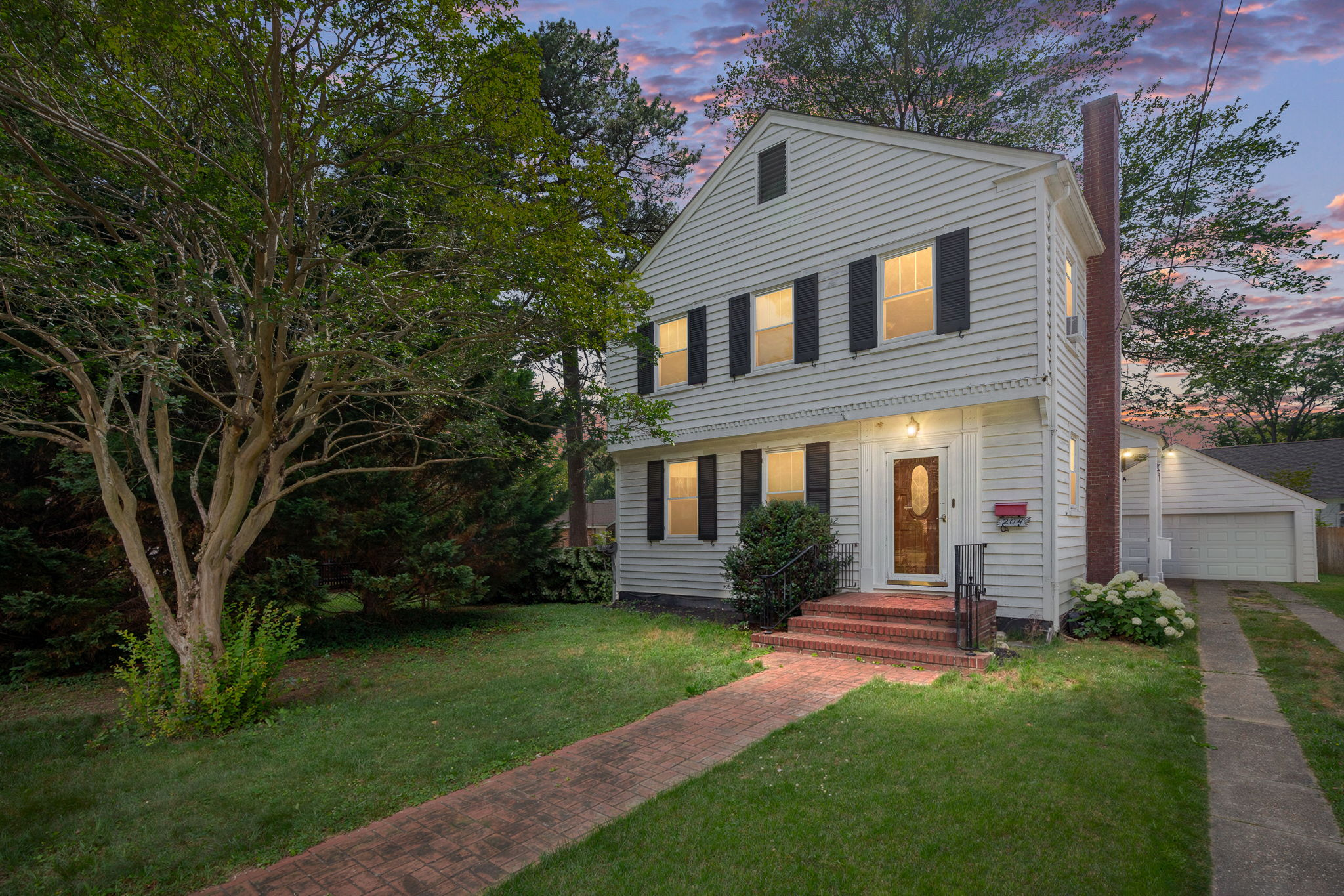 Exterior front facade at twilight with warm entry lighting
