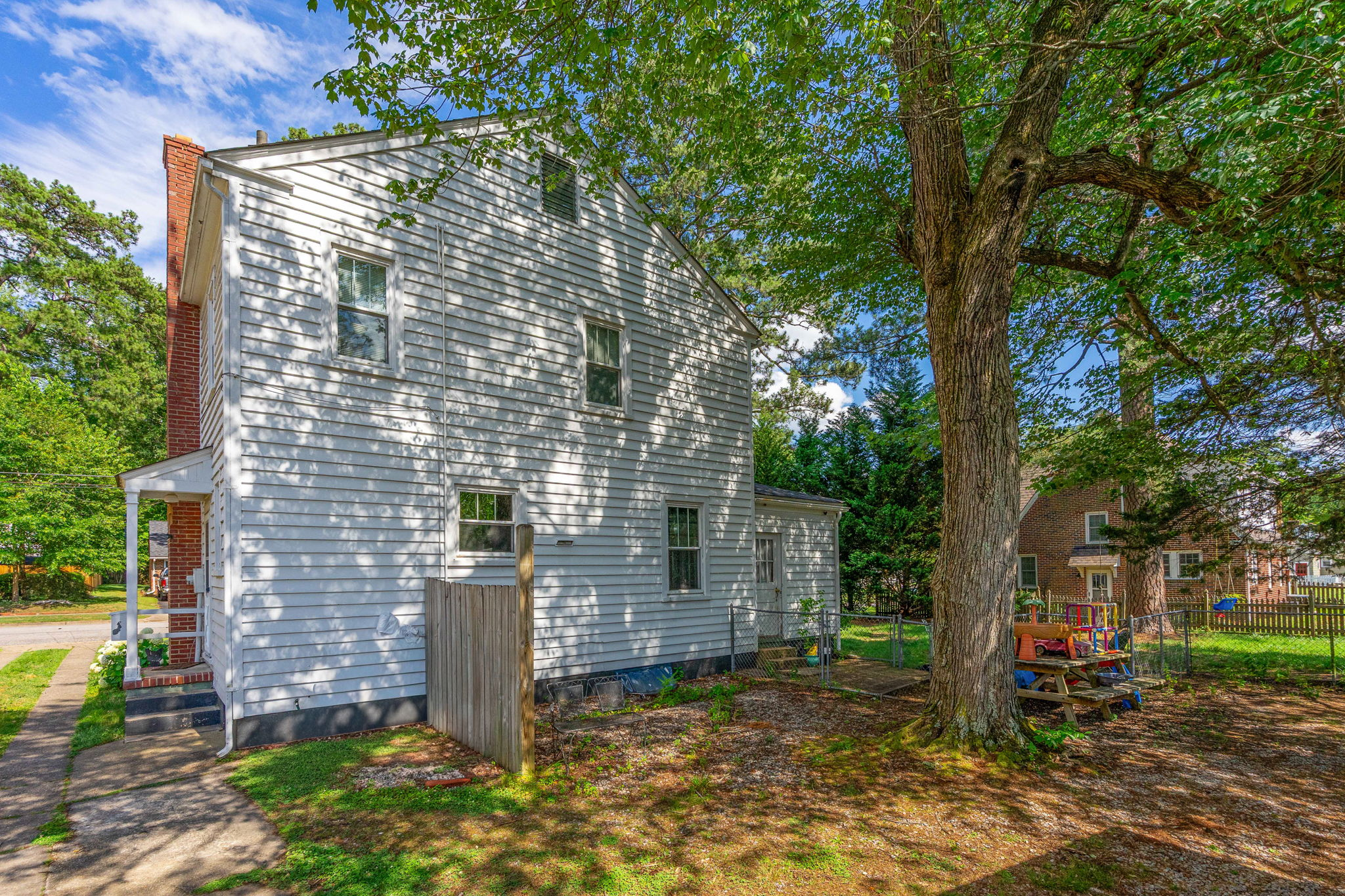 Side exterior view with exposed brick chimney