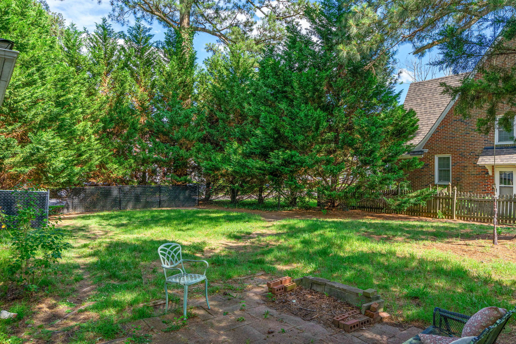 Backyard patio area with brick surface and lawn