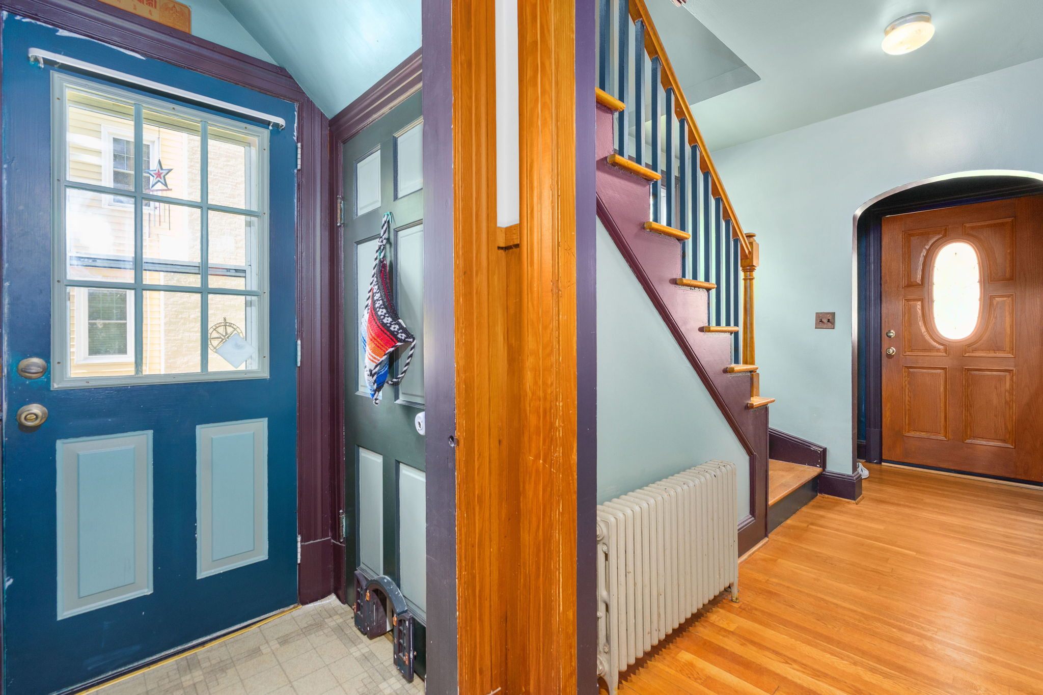 Foyer with original hardwood staircase and stained glass window