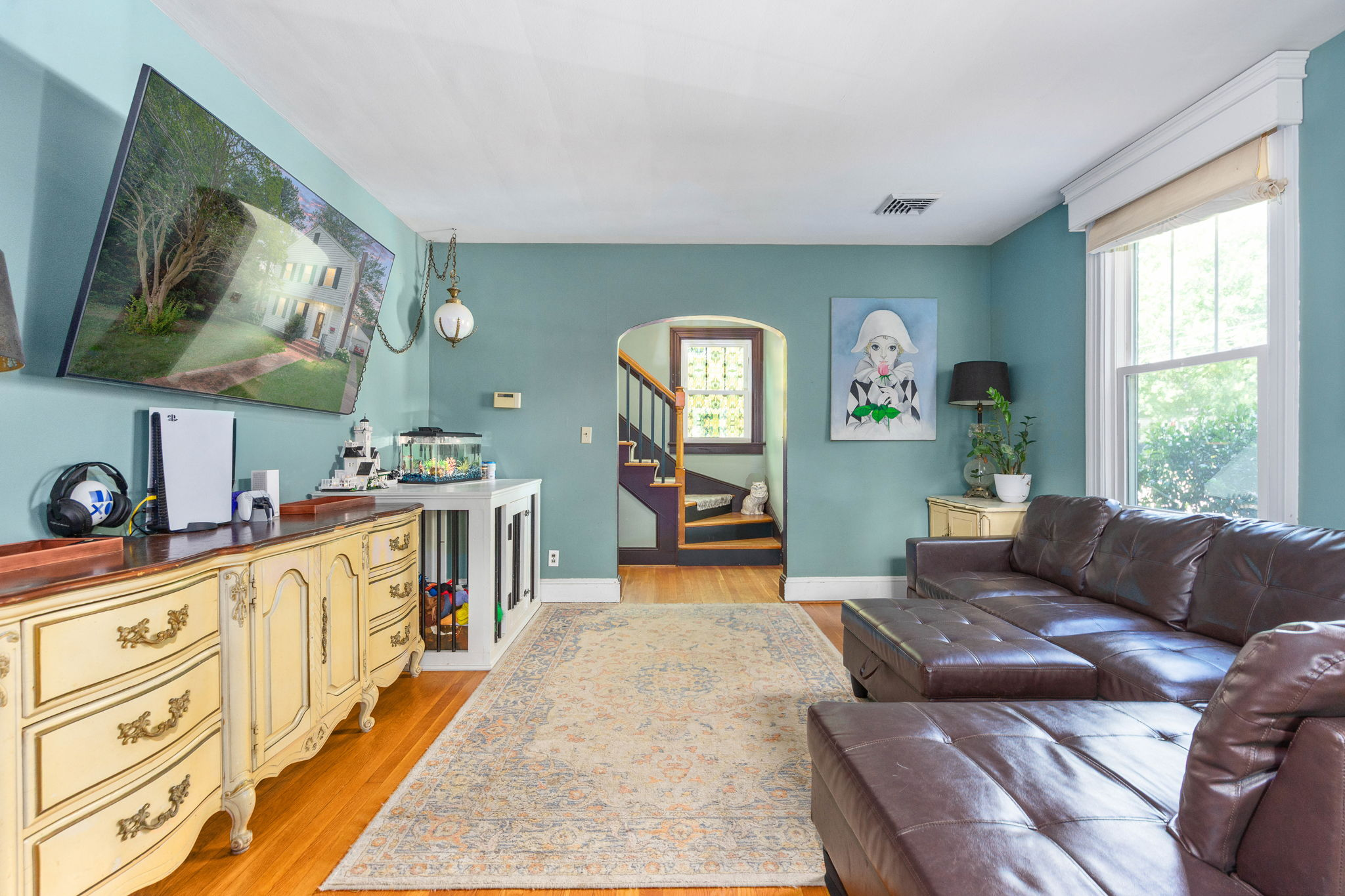 Living room with arched entry leading to stairwell