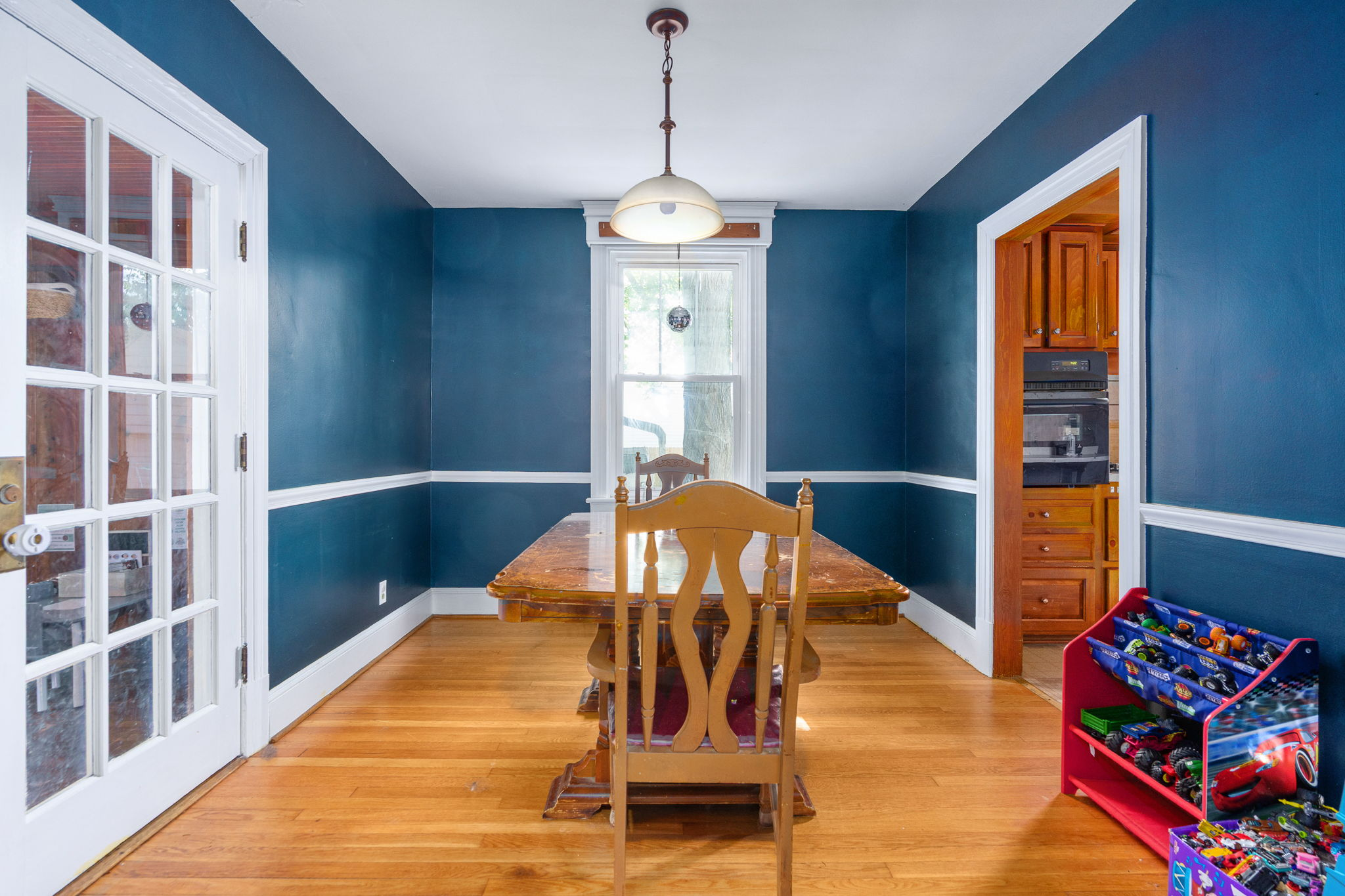 Dining room with deep blue walls and white wainscoting