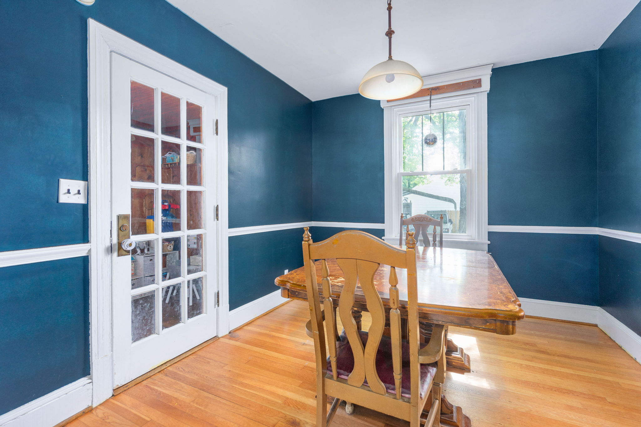 Dining room with deep blue walls and white wainscoting