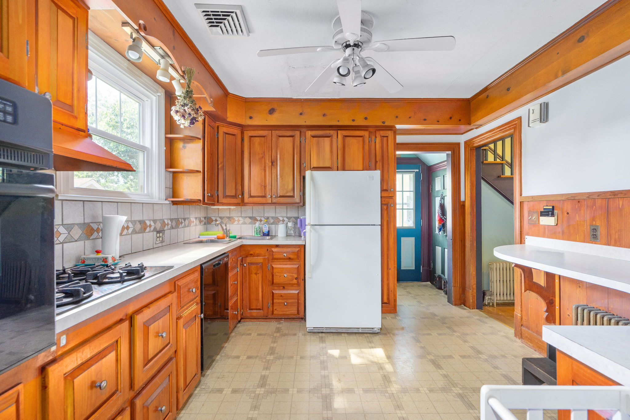 Kitchen with honey-toned wood cabinetry and tile backsplash