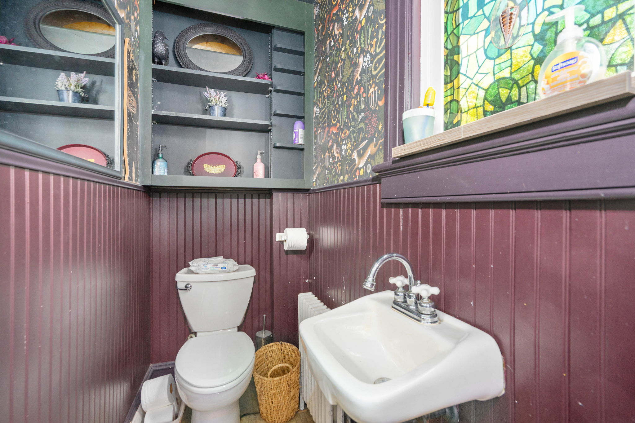 Bathroom with plum wainscoting and vintage stained glass window