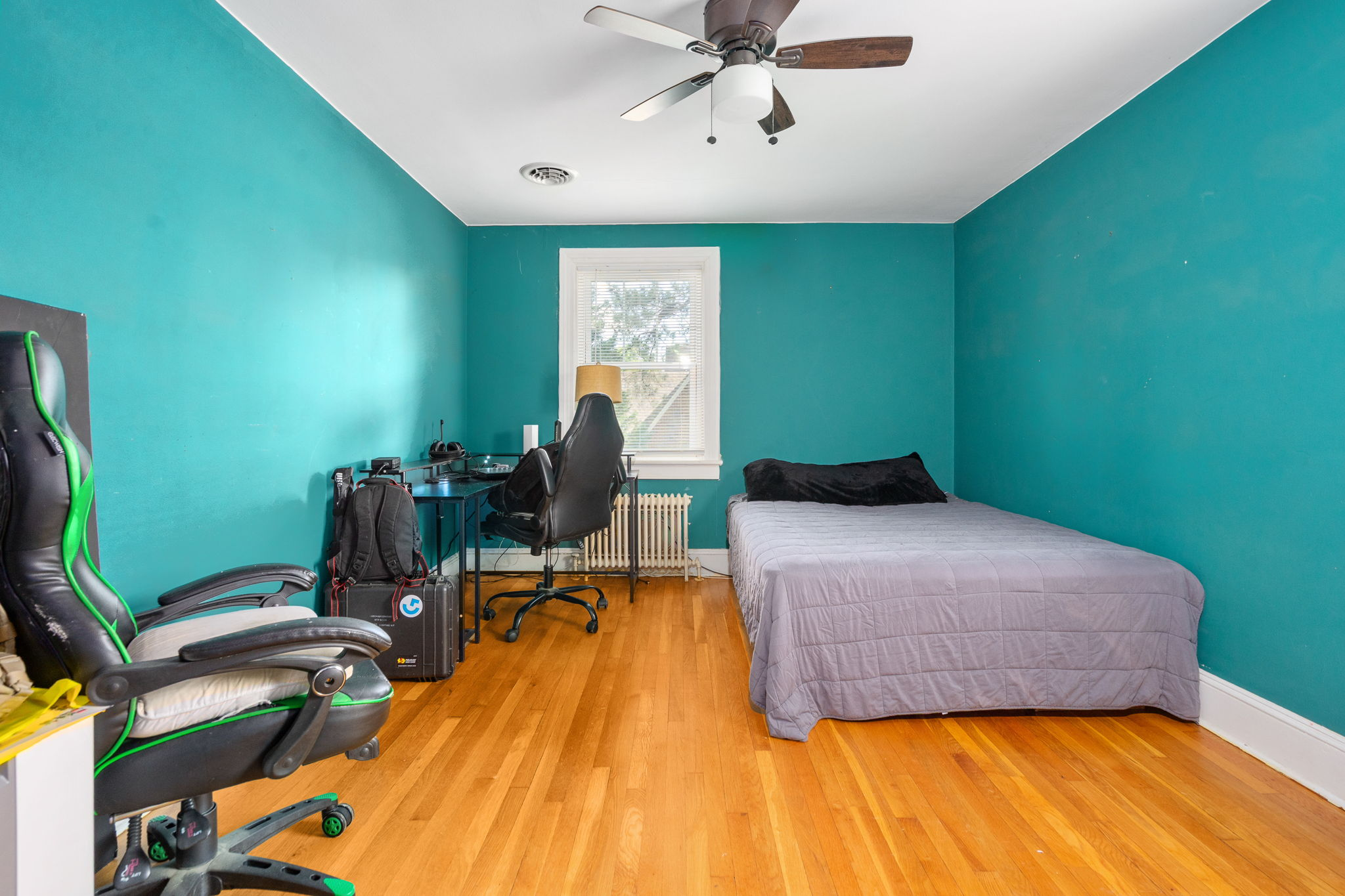 Bedroom with oak hardwood floors and teal accent walls
