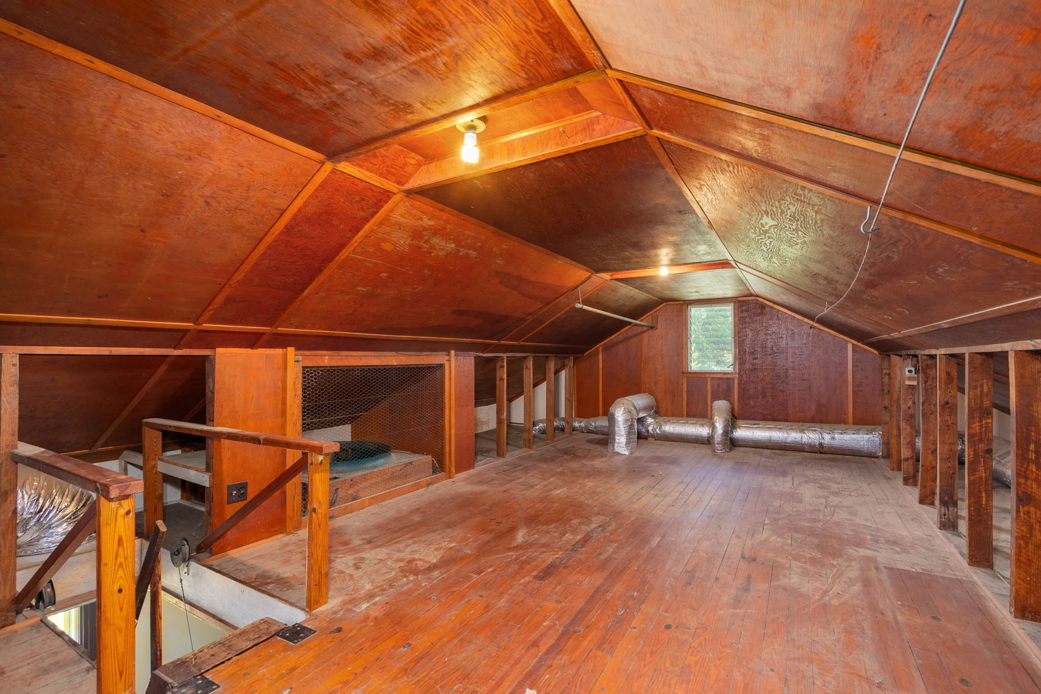 Unfinished attic space with exposed wood paneling