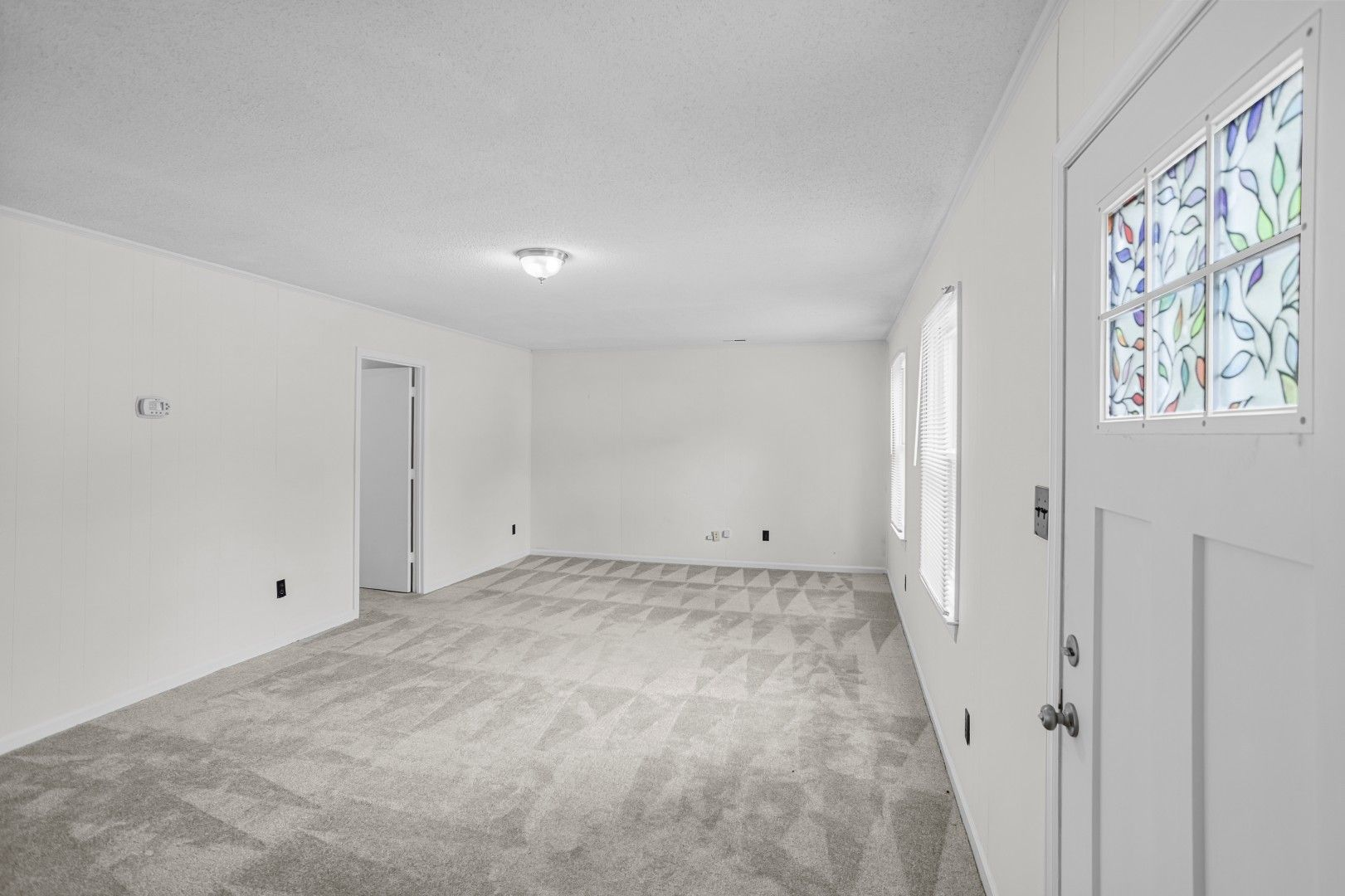 Living room with fresh carpet and natural light from windows