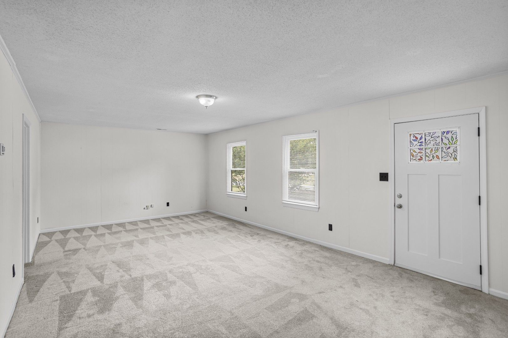 Wide living room view looking toward front entrance