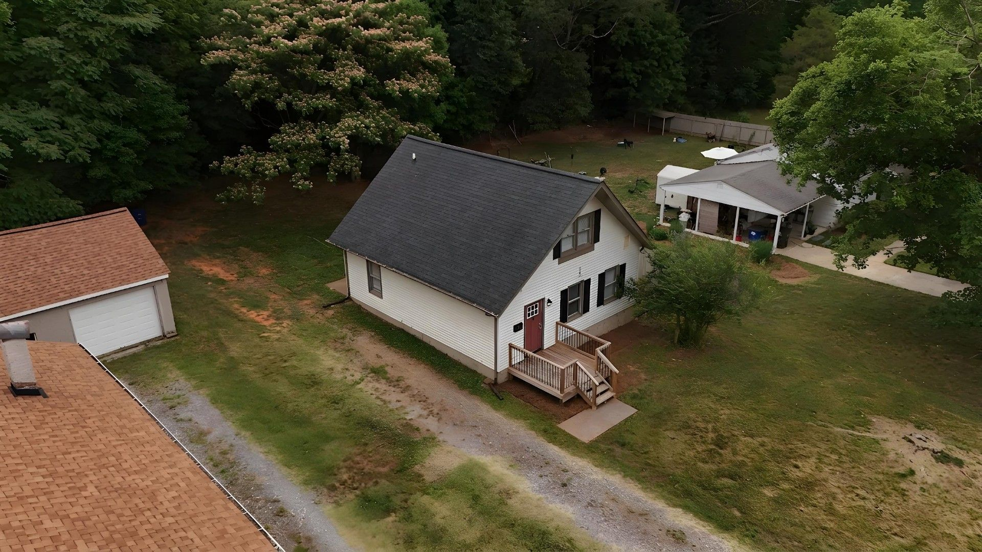 Aerial view of property showing roof, yard, and surrounding lots