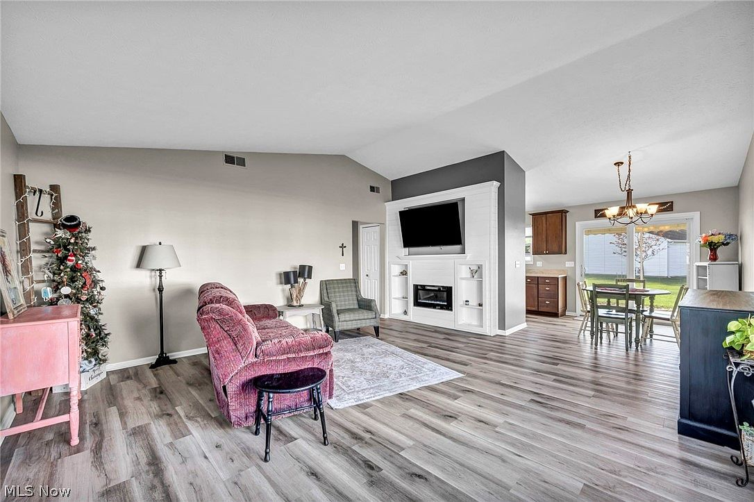 Open-concept living area with vaulted ceilings, fireplace, and dining space