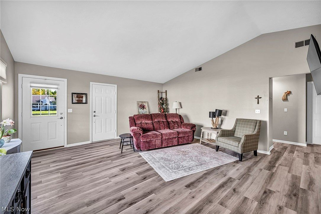 Living room with vaulted ceiling and vinyl plank flooring