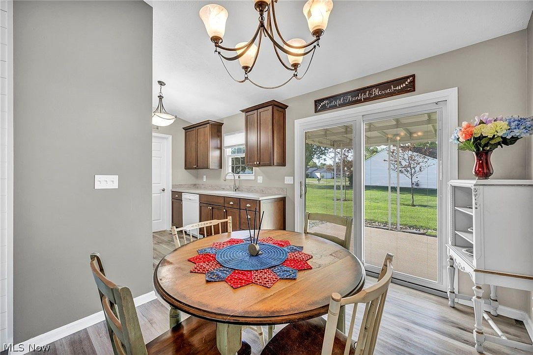 Dining area transitioning into kitchen with wood-look plank flooring