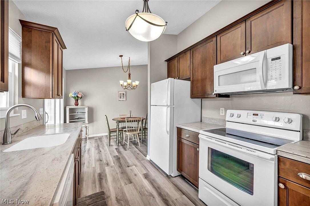 Kitchen and adjacent dining area with stained oak cabinetry