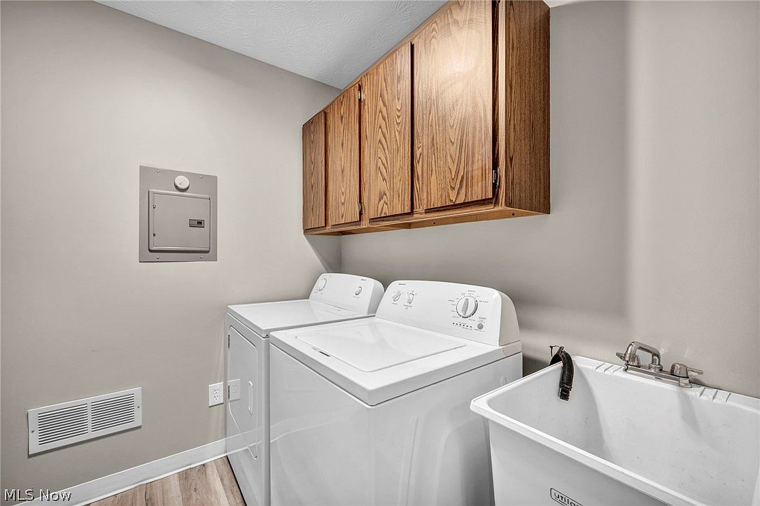 Laundry room with utility sink and oak cabinetry
