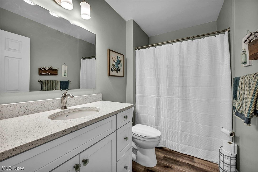 Guest bathroom with tub/shower combo and white vanity