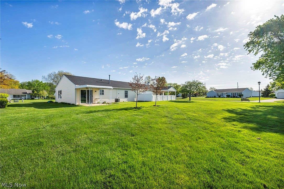 Wide-angle shot of expansive rear backyard with open lawn