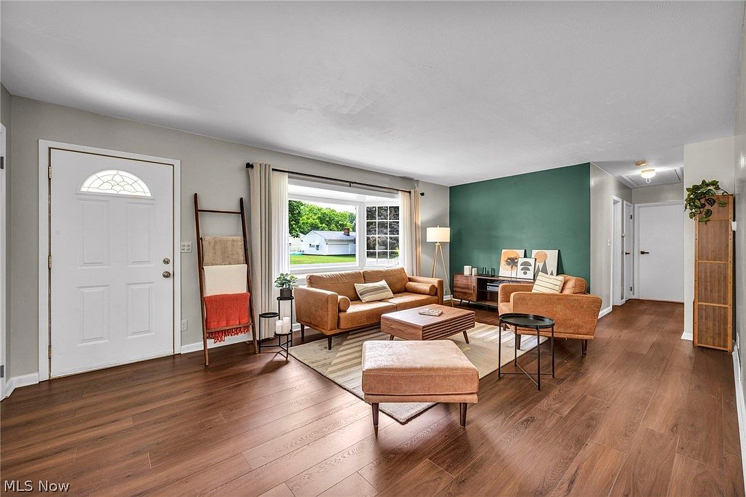 Living room with green accent wall and natural light