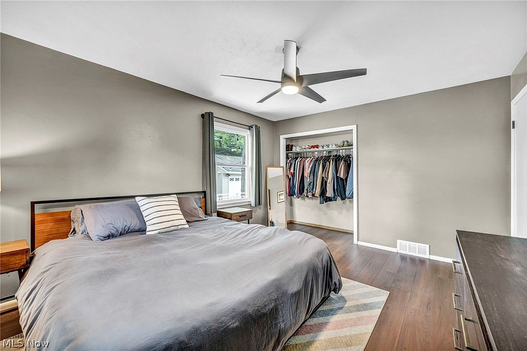 Primary bedroom with wood floors and natural light