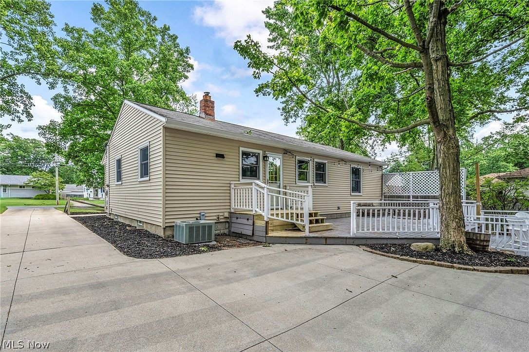 Rear view of home with deck and mature tree
