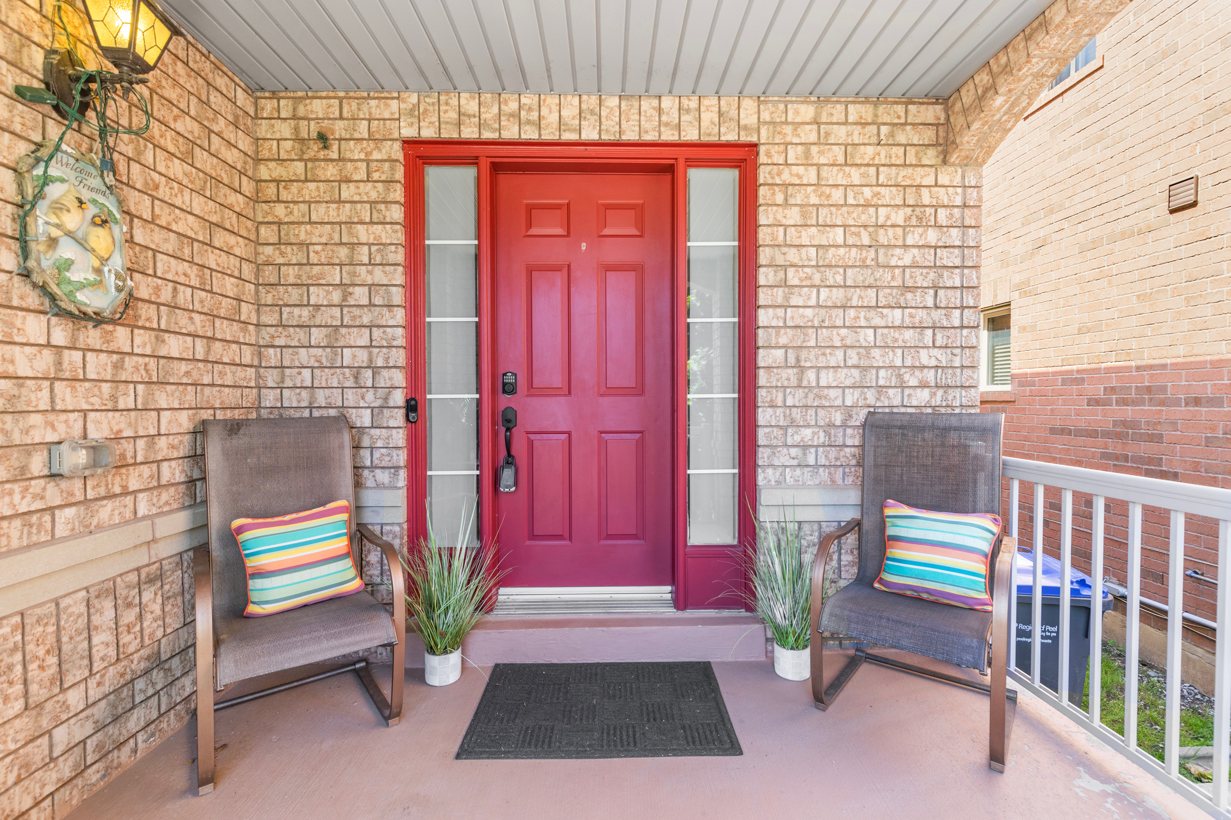 Front entry porch with red door and tan brick