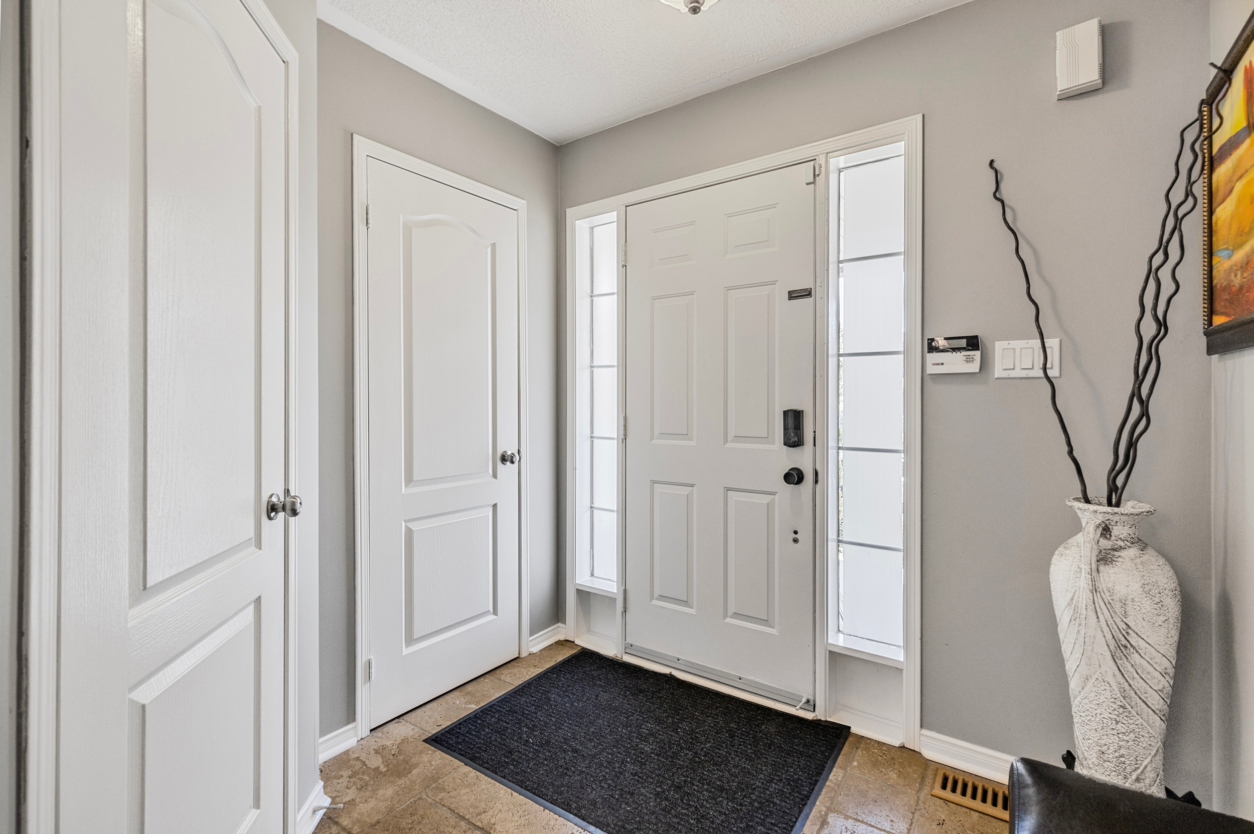 Home entryway foyer with white door and grey walls