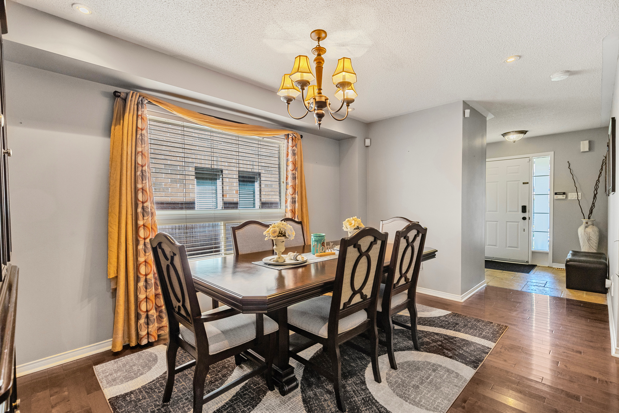 Furnished dining room with six chairs and yellow curtains
