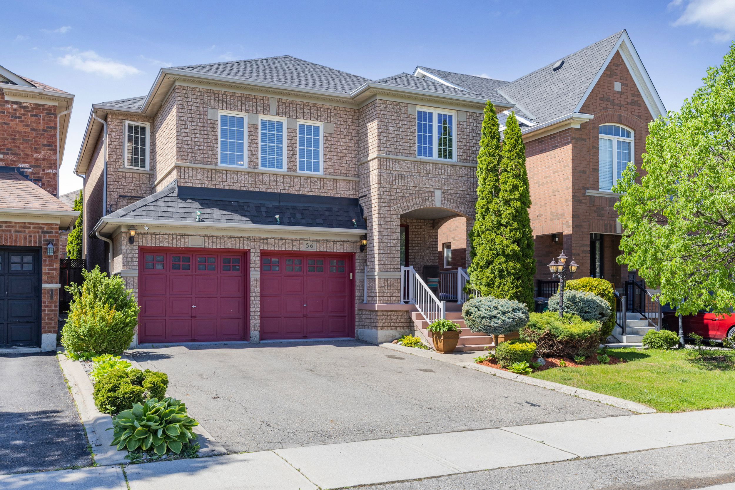 Street-level view of the brick home with manicured landscaping