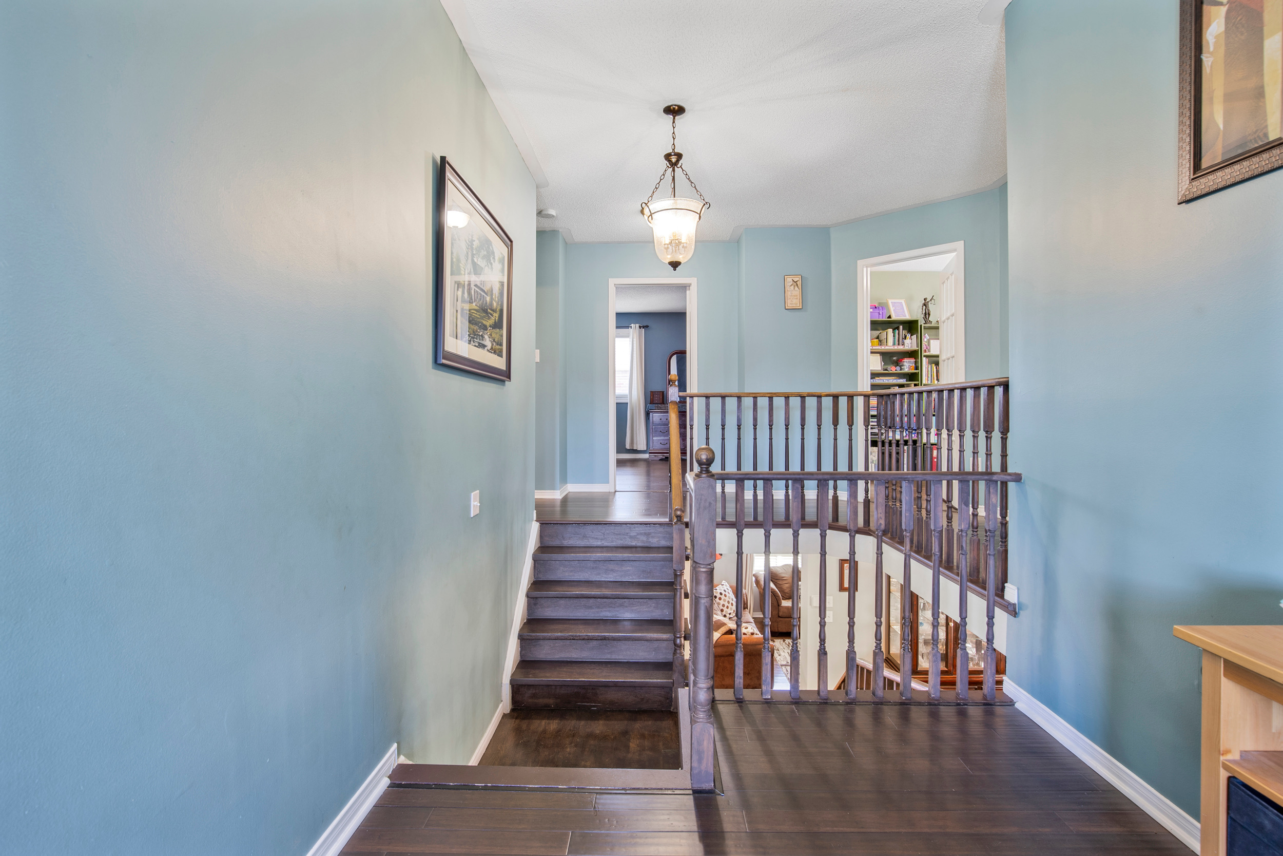 Staircase and upper hallway landing with hardwood stairs