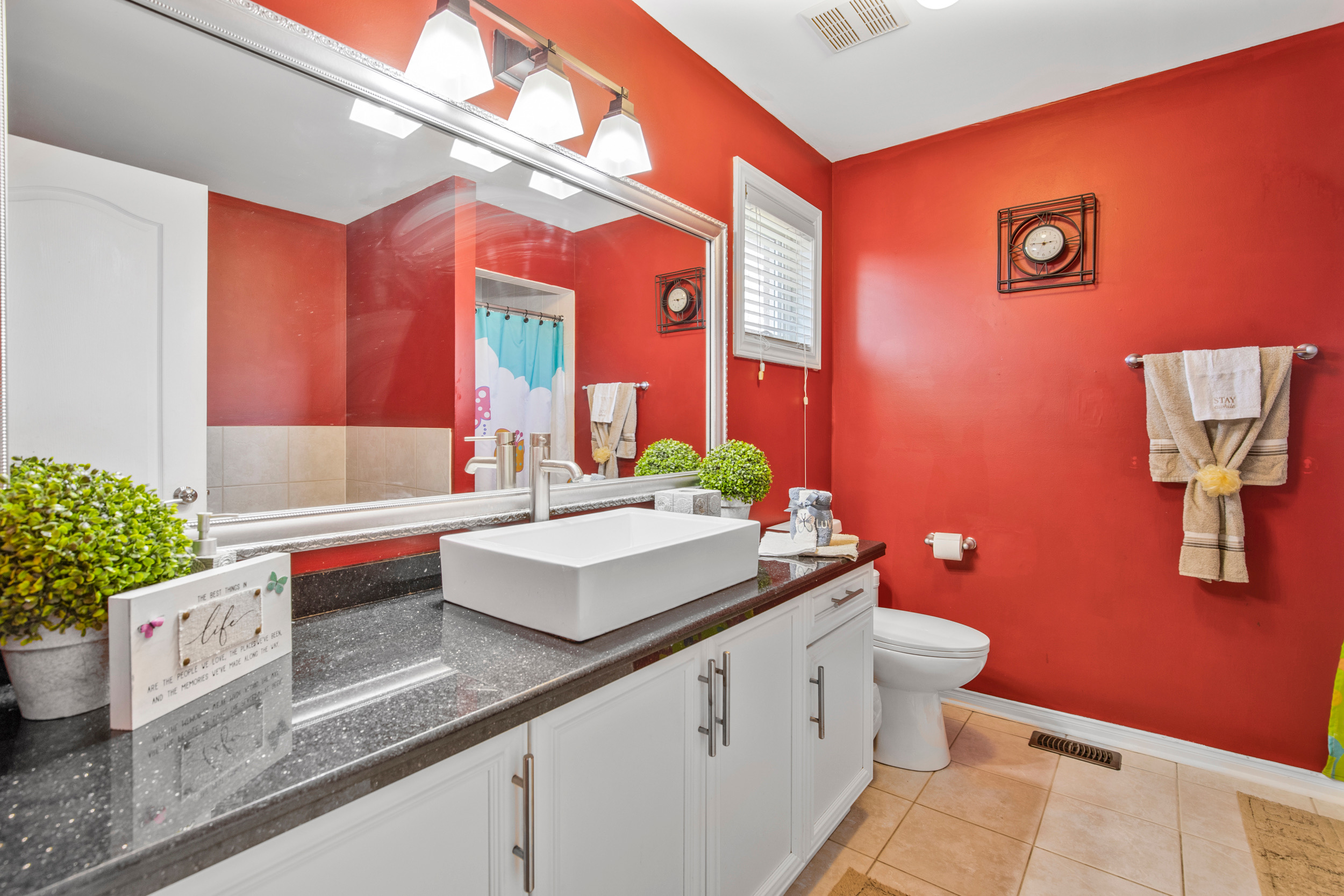 Bathroom with red walls and white vanity with vessel sink
