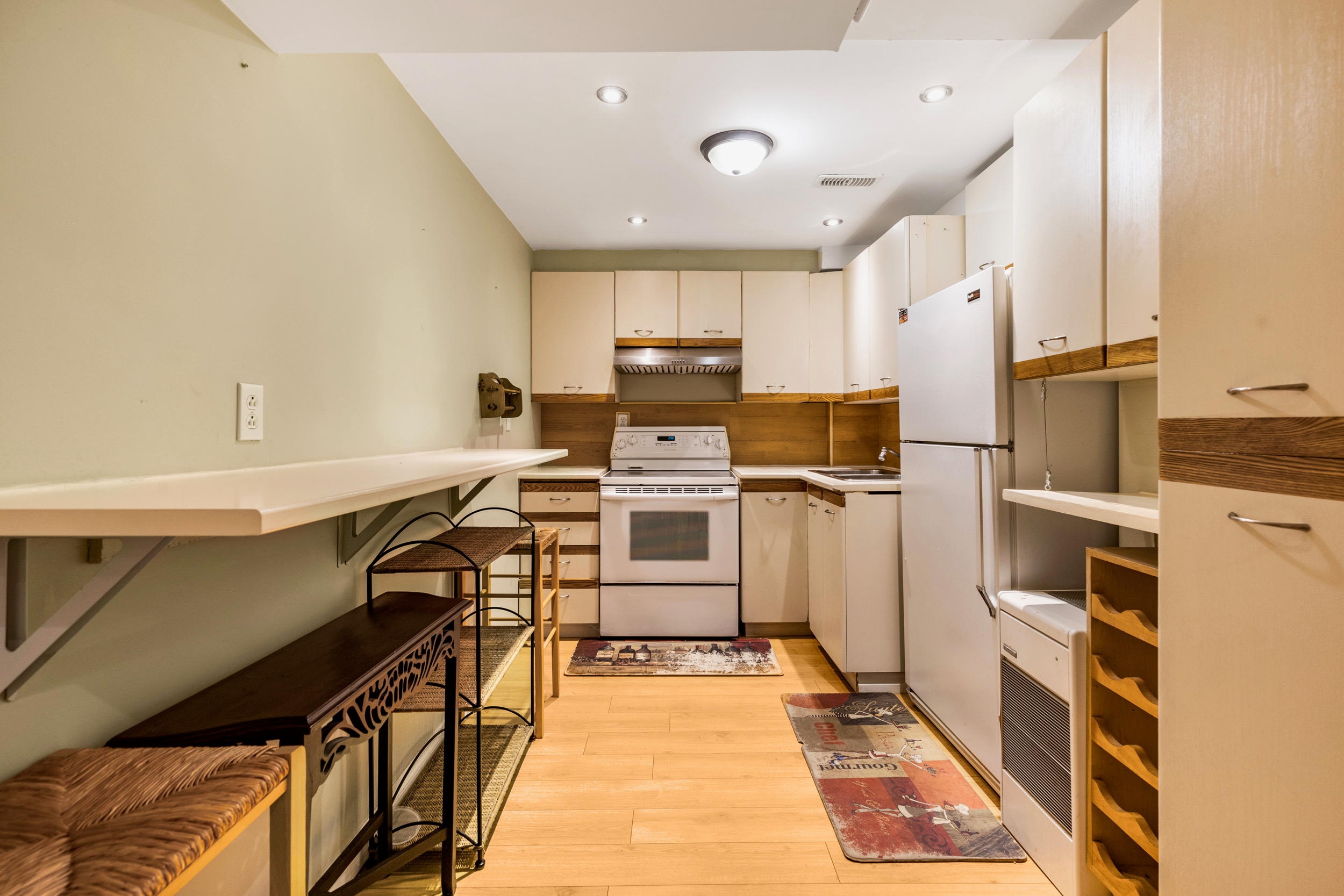 Galley kitchen layout with light wood-toned cabinets