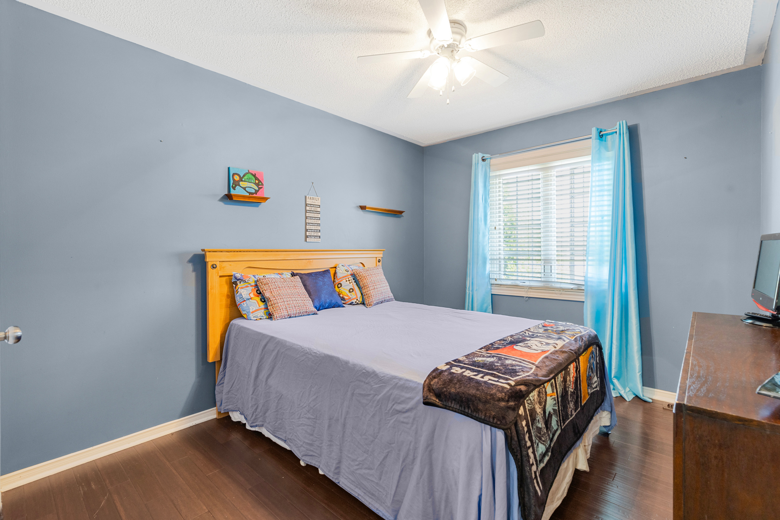Bedroom with blue walls and dark laminate flooring