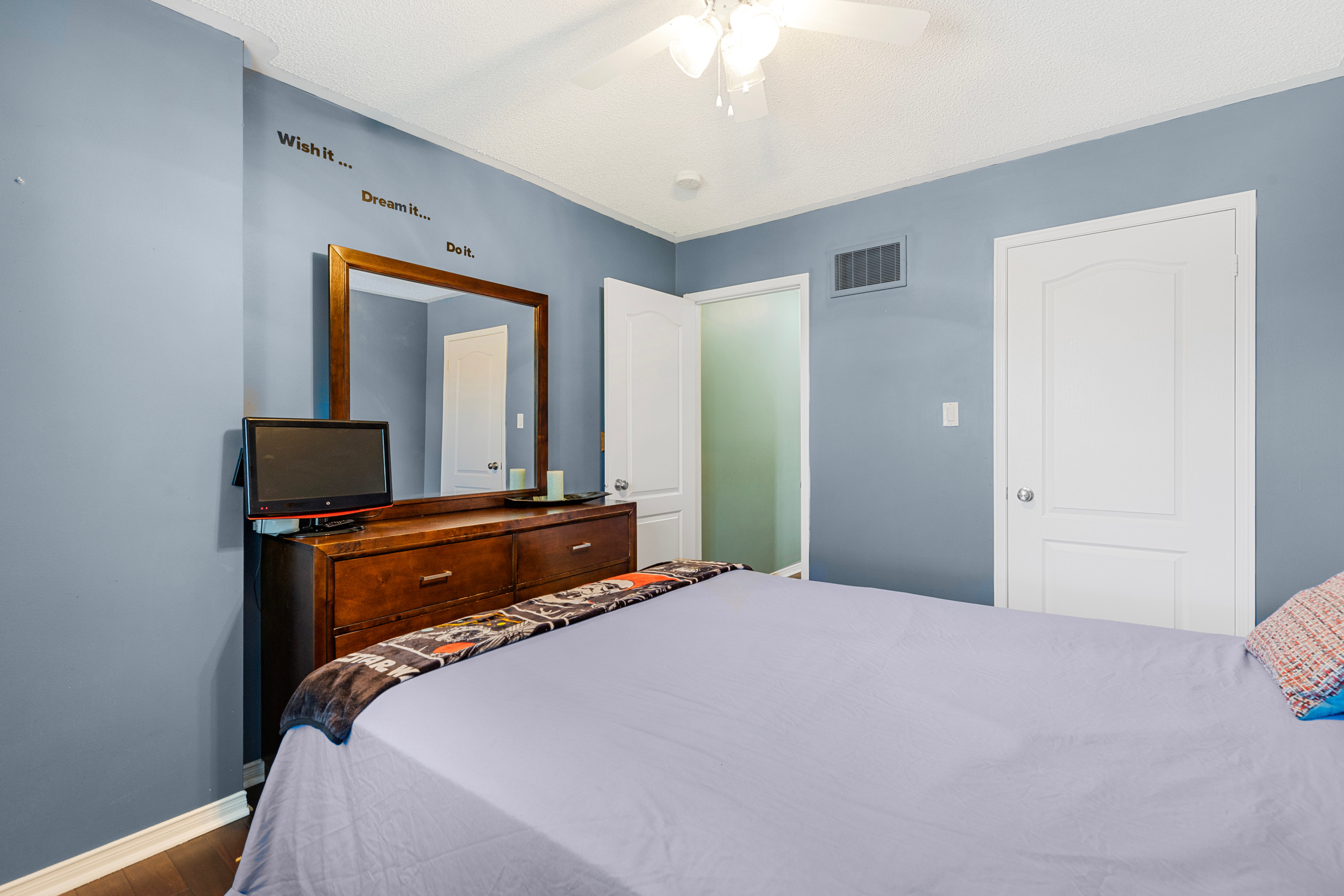 Bedroom with blue walls, wood flooring, and window blinds