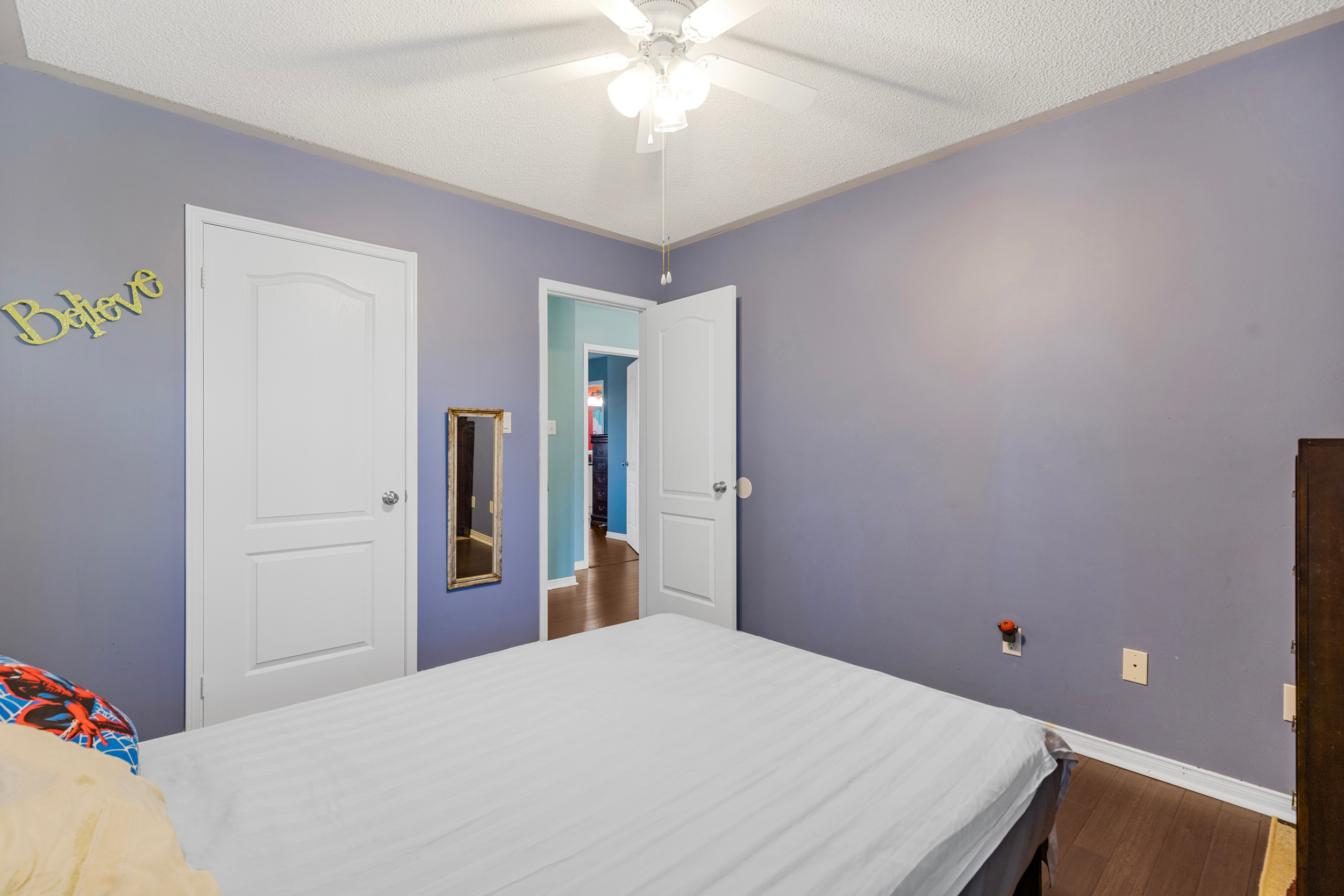 Bedroom with blue walls and ceiling fan