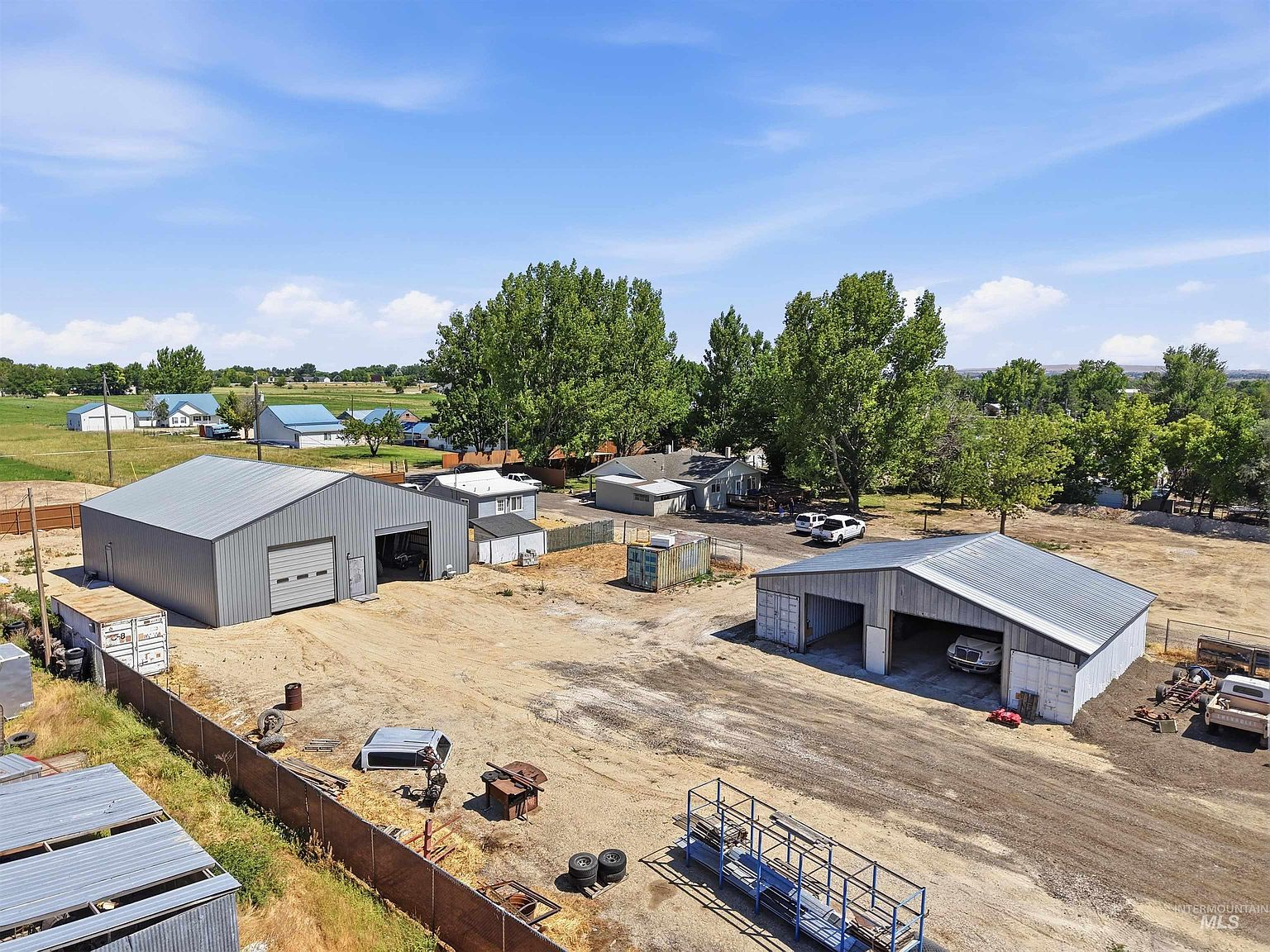 Aerial view of 79 N Robinson Rd showing the main home, two shops, guest house, and 6 acres of land