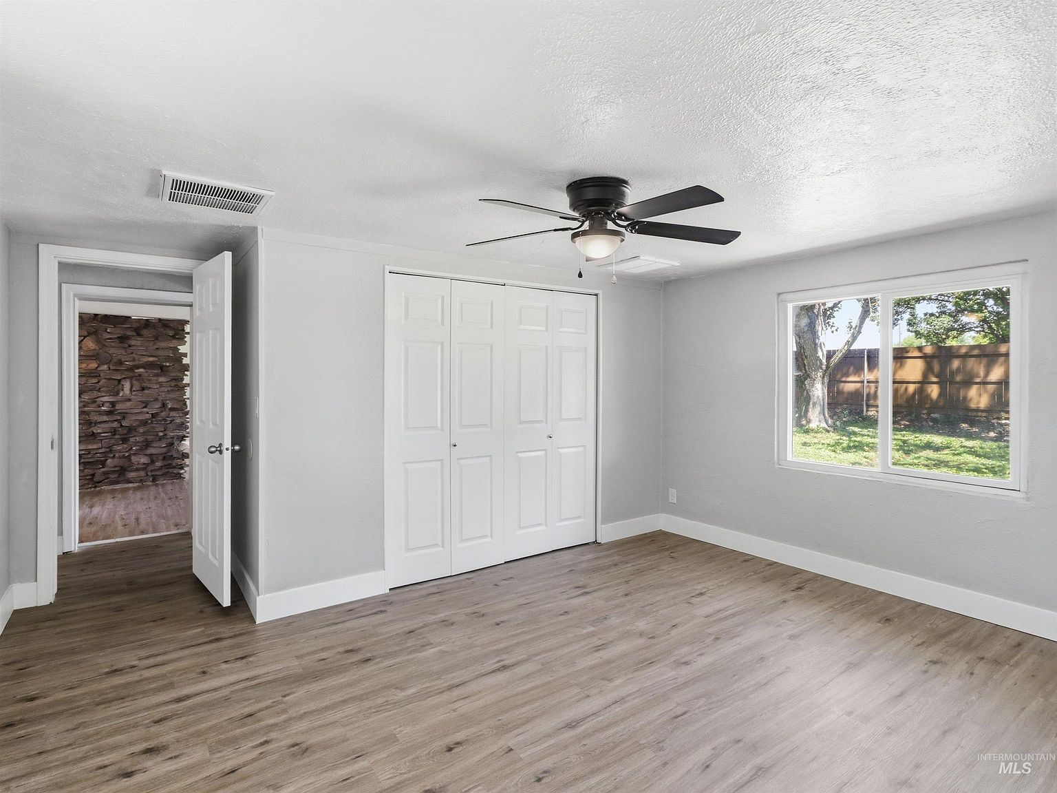 Bedroom with light wood-look flooring and white trim